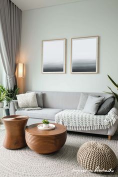 a living room filled with furniture and two pictures hanging on the wall above it's windows