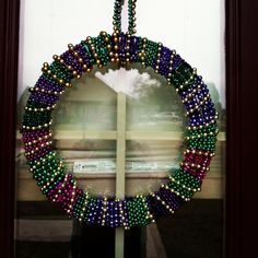 a beaded wreath is hanging on the front door with a window in the background