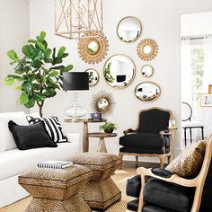 a living room filled with lots of furniture and mirrors on the wall above it's coffee table