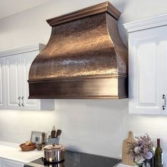 a stove top oven sitting inside of a kitchen next to white cabinets and counter tops