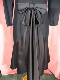 "Dramatic 70's cocktail dress in black crepe and satin by Estevez, who was the youngest designer to win the Coty award. Beautifully made, it's completely lined, and about a size 6. It measures approx. 14\" across slightly padded shoulders, up to 37\" bust, 20 1/2\" outside sleeve length, 28\" waist, 38\" hips, and 43\" overall length. It's in excellent, like new, condition. See my entire shop collection here https://www.etsy.com/shop/RobinClaytonVintage" Elegant Black Dress With Satin Trim, Silk Party Dress With Satin Trim, Chic Party Dresses With Satin Trim, Chic Evening Dress With Satin Trim, Evening Dress With Satin Trim, Chic Evening Dresses With Satin Trim, Evening Satin Dress With Satin Trim, Elegant Party Dresses With Satin Trim, Black Silk Evening Dress For Formal Occasions