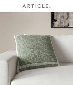 a white couch with a green pillow sitting on it's back and the words article written