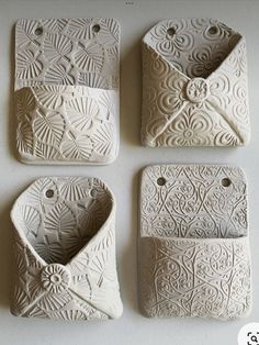 four pieces of white pottery sitting on top of a table