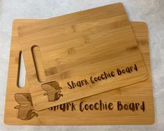 two chopping boards with the words shark cookie board and ginger cookie board on them