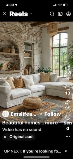 a living room filled with furniture next to a brick wall and window covered in windows