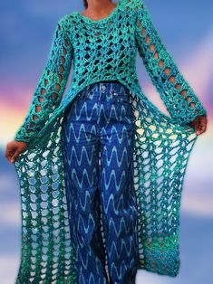 a woman wearing blue pants and a green crochet sweater with waves on it