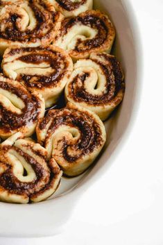 cinnamon rolls in a white bowl on a table