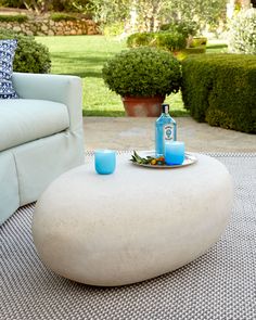 a white couch sitting on top of a rug next to a table with blue candles