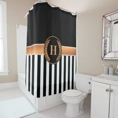 a black and white striped shower curtain with a monogrammed h on the front