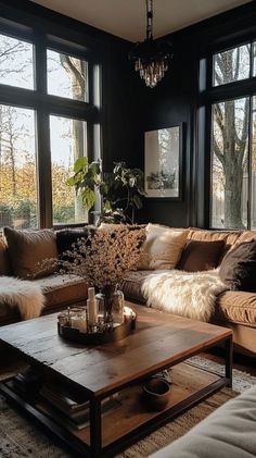 a living room filled with lots of furniture and large windows overlooking the trees in the distance