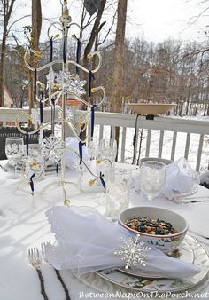 a table set with plates, silverware and napkins for an outdoor winter wedding