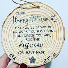 a hand holding a wooden plaque with the words, give happy retirement may you be proud of the work you have done