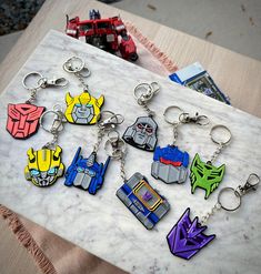 six different keychains are sitting on a marble slab, each with an image of the same character