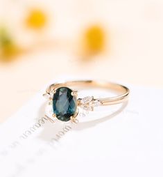 a close up of a ring on top of a piece of paper with flowers in the background