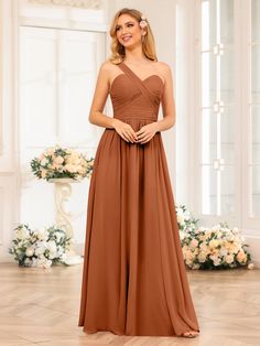 a woman in a brown bridesmaid dress standing on a wooden floor with flowers