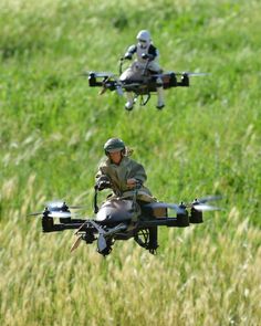 two people are flying with remotes in their hands and one is holding a camera