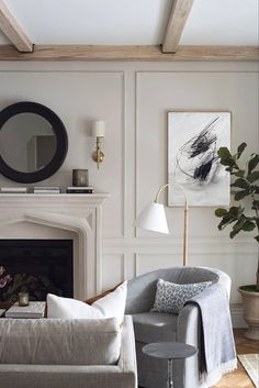 a living room filled with furniture and a fire place in front of a white fireplace