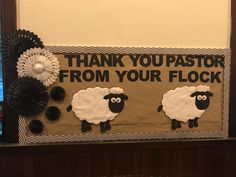 two sheep are standing in front of a sign that says thank you pastor from your flock