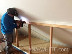 a man in blue shirt working on a wall