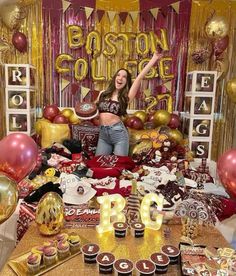 a woman standing in front of a table filled with cupcakes and cake decorations