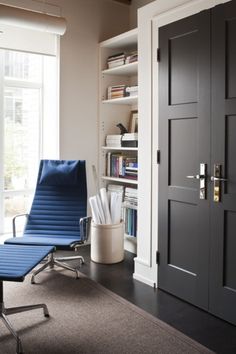 the door is open and there is a blue chair next to it in front of a bookshelf