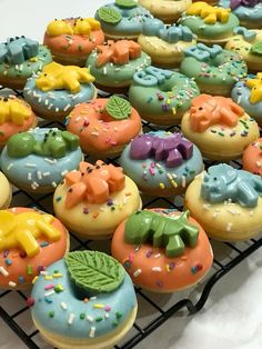 there are many decorated doughnuts on the cooling rack