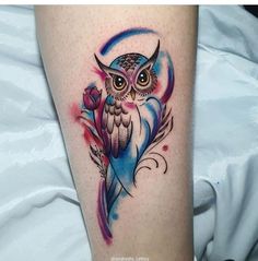 an owl tattoo on the leg with a flower in it's center and a crescent around its neck