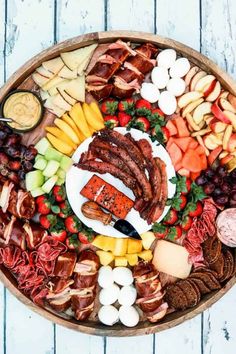 an assortment of meats and cheeses on a platter