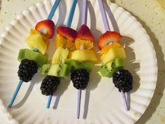 fruit skewers are arranged on a paper plate