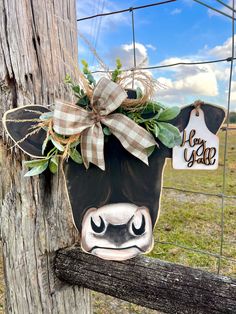 a cow head hanging on the side of a fence with a tag that says happy new year