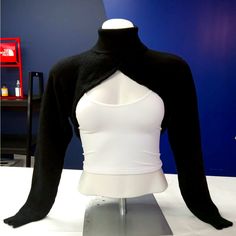 a black and white top on display in a room with a blue wall behind it