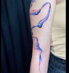 a woman's arm with blue and pink ink on the left side of her arm