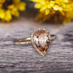 an engagement ring with a pear shaped morganite surrounded by white and brown diamond accents