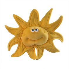 a yellow stuffed sunflower with eyes on it's face and mouth, sitting in front of a white background