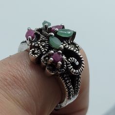 This ring is 925 sterling silver with genuine green emeralds, red ruby and marcasite. We have in a size 7.5, this can be sized to your specification, please message us to discuss sizing your ring or engraving options. All of our jewelry is hand polished and shipped to you in a stylish gift box. We are happy to gift wrap for you. It is important to us that each customer be thrilled with their purchase. We are grateful for thousands of positive reviews. Silver Emerald Multi-stone Rings, Green Ruby Ring Jewelry, Silver Ruby Ring With Multi-stone Details, Silver Ruby Ring With Multi-stones, Silver Ruby Ring With Multiple Stones, Silver Emerald Ring, Emerald Gem, Real Turquoise, Bronze Ring