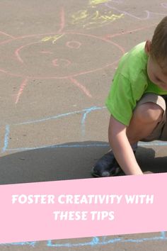 a little boy kneeling down on top of a skateboard in front of chalk drawings