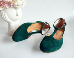 "❣ PRODUCT DESCRIPTION Step back in time with these green ballerinas and make every stride a statement of timeless elegance. Embrace the allure of yesteryear with a design that flairs vintage sophistication.  The rich, deep green hue adds a touch of opulence to your ensemble. Enjoy all-day comfort with a round, closed-toe design that balances style and practicality.  The T-strap detailing brings a timeless charm, adding a hint of romance to your look.  Ensure a secure fit and effortless style with the ankle closure, perfect for on-the-go fashionistas. Whether you're strolling through the city streets or stepping into a semi-formal event, these low-heeled shoes offer the perfect blend of comfort and style.  Pair them with your favorite dress for a chic, feminine look, or dress up your offic Green Ballerina, Shoes Elegant, T Strap Flats, Ballerina Pumps, Original Bags, Green Suede, Ballet Flat Shoes, Rubber Heels, T Strap