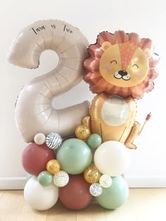 a number two balloon with a lion on it and balloons around it in the shape of numbers