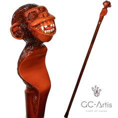 a red monkey statue holding a stick with its mouth open and eyes closed, in front of a white background