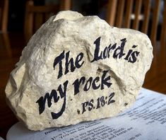 a rock that says the lord's my rock is on top of an open book