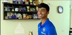 a man holding a trophy in his hand and smiling at the camera while wearing a blue shirt