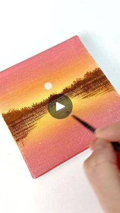 someone is using a marker to paint the sunset