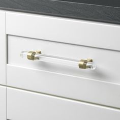 a white cabinet with brass handles and knobs