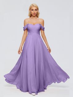 a woman in a long purple dress with off the shoulder sleeves and pleaed skirt