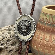 This unique necklace from Fancy Fox Boutique is a handcrafted 3D Concho Buffalo Bolo Tie. The pendant is made of silver tone metal and features a beautiful oval shape with a diffused blue main stone. The necklace is 37 inches long and made of high-quality leather and mixed materials.  This necklace is perfect for any occasion, including engagements, weddings, anniversaries, graduations, birthdays, and more. It is a great gift for Father's Day, Mother's Day, Christmas, and Valentine's Day. The ne Bolo Tie Necklace, Tie Necklace, Bolo Tie, Unique Necklace, Boutique Accessories, Brown Silver, Tie Accessories, Unique Necklaces, Gifts For Father