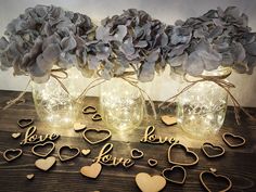 three mason jars filled with love and hearts are sitting next to each other on a table