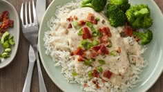 a plate with rice, broccoli and chicken on it next to a fork