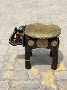 an elephant stool sitting on top of a sidewalk