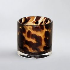 a brown and black glass vase sitting on top of a table