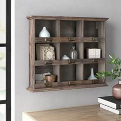 a wooden shelf filled with books and vases